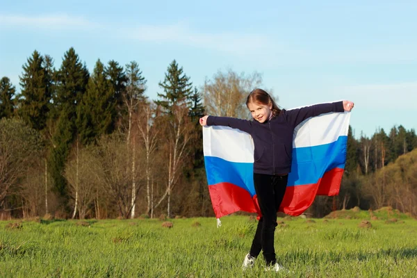 Fille tenant un grand drapeau russe — Photo