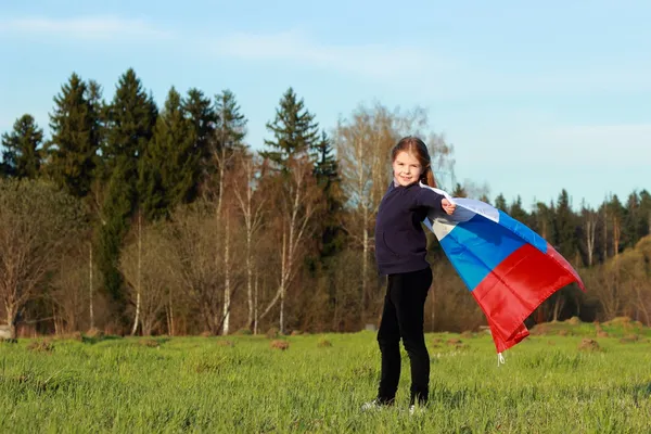 Fille tenant un grand drapeau russe — Photo