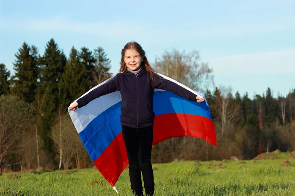 Fille tenant un grand drapeau russe — Photo