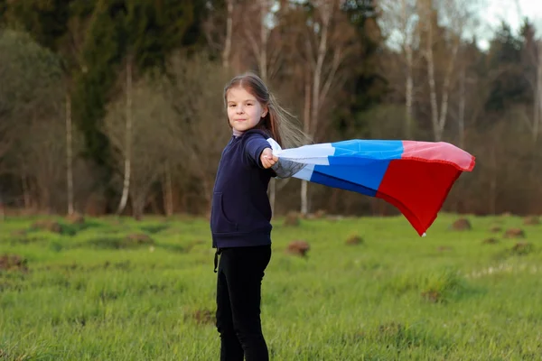 Fille tenant un grand drapeau russe — Photo