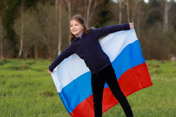 Girl holding a large Russian flag — Stock Photo, Image