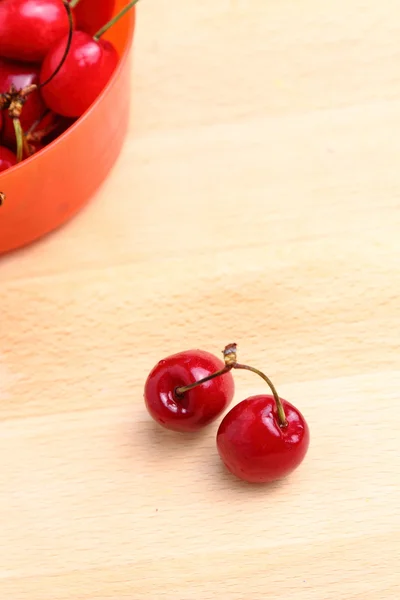 Cerezas dulces en un tazón de plástico naranja — Foto de Stock