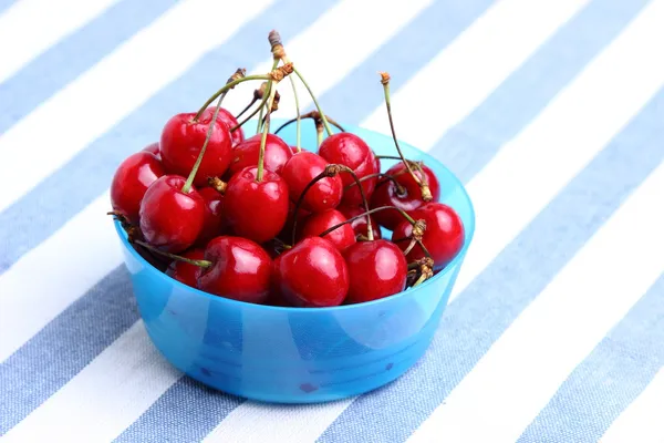 Ripe sweet cherries in bowl on tablecloth — Stock Photo, Image