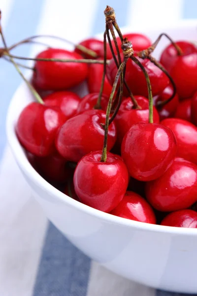 Ripe sweet cherries in bowl on tablecloth — Stock Photo, Image