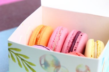 Açık mavi renkli kağıt kutusunda altı lezzetli tatlı renkli macarons
