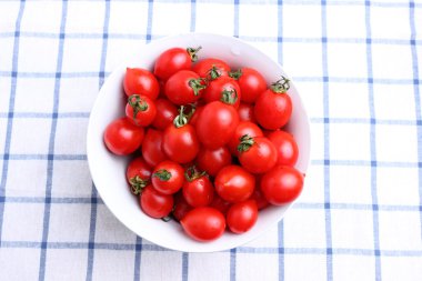 masa örtüsü üzerinde kase kiraz domates