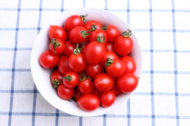 masa örtüsü üzerinde kase kiraz domates