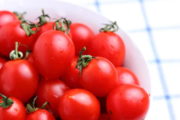 Tomates cereja em tigela na toalha de mesa — Fotografia de Stock