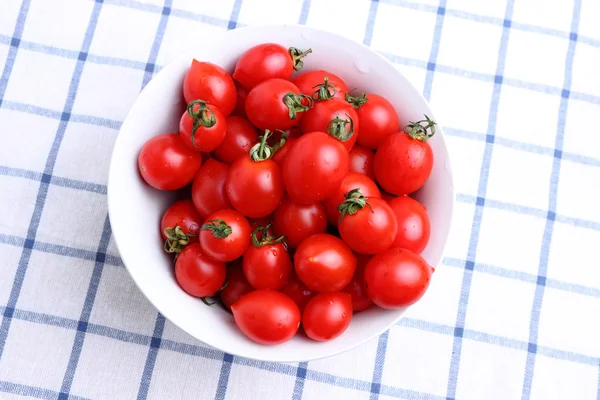 Tomates cereja em tigela na toalha de mesa — Fotografia de Stock