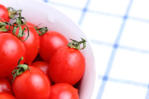 Tomates cereja em tigela na toalha de mesa — Fotografia de Stock