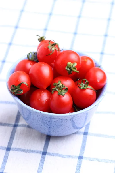 Cherry tomatoes in bowl on tablecloth — Stock Photo, Image