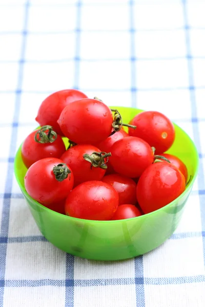 Tomates cereja em tigela na toalha de mesa — Fotografia de Stock