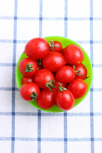 Tomates cereja em tigela na toalha de mesa — Fotografia de Stock