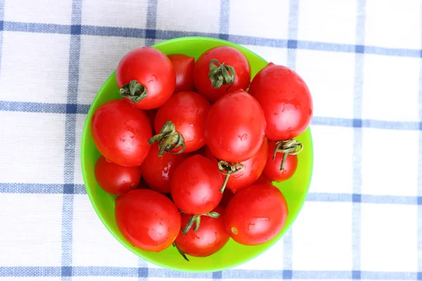 Cherry tomatoes in bowl on tablecloth — Stock Photo, Image