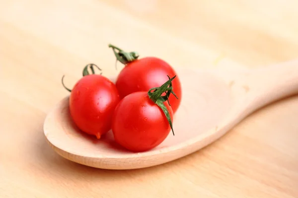 Tomates cereja em colher de madeira — Fotografia de Stock