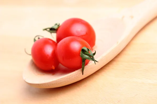 Tomat ceri dalam sendok kayu — Stok Foto