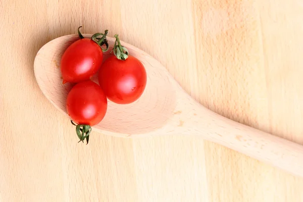 Tomates cereja em colher de madeira — Fotografia de Stock