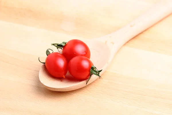 Tomates cereja em colher de madeira — Fotografia de Stock