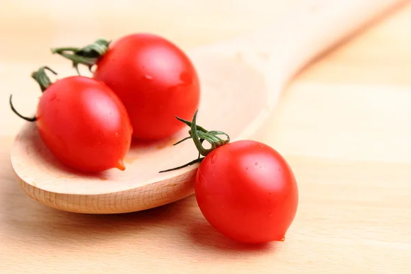 Tomates cereja em colher de madeira — Fotografia de Stock