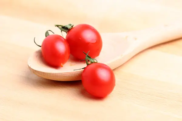 Tomates cereja em colher de madeira — Fotografia de Stock