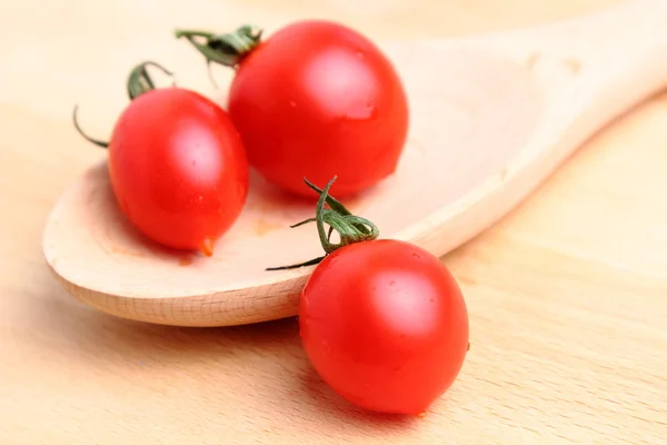 Tomates cereja em colher de madeira — Fotografia de Stock