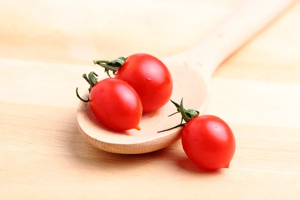 Tomates cereja em colher de madeira — Fotografia de Stock