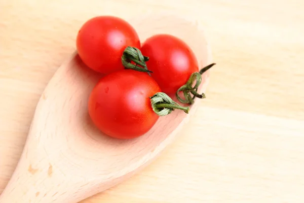 Tomates cereja em colher de madeira — Fotografia de Stock