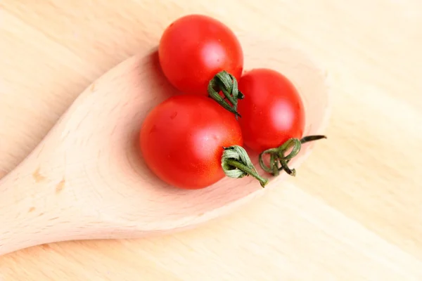 Tomates cereja em colher de madeira — Fotografia de Stock