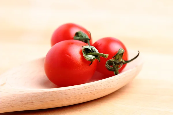 Tomates cereja em colher de madeira — Fotografia de Stock