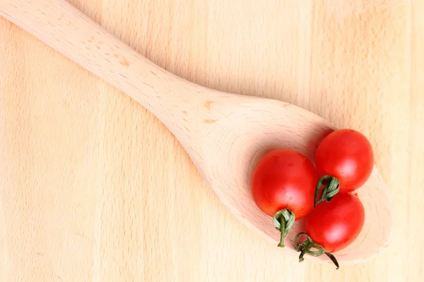 Tomates cereja em colher de madeira — Fotografia de Stock