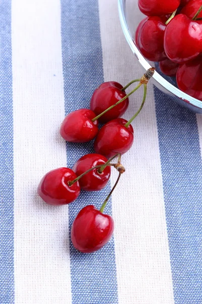 Cerezas rojas sobre un mantel azul — Foto de Stock