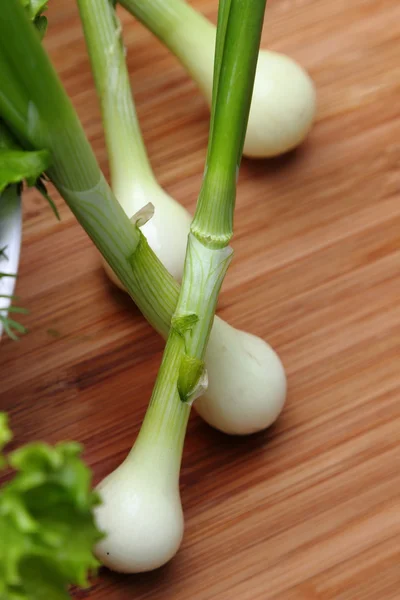 Молодые луковые луковицы с зеленой капустой — стоковое фото