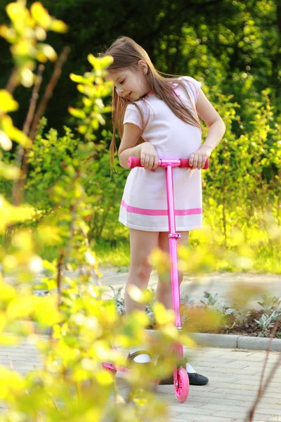 Bambina cavalcando scooter — Foto Stock