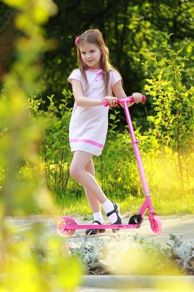 Liten flicka ridning scooter — Stockfoto