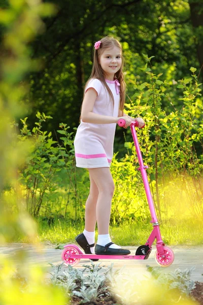 Liten flicka ridning scooter — Stockfoto