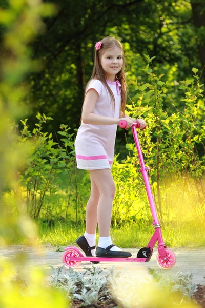 Weinig meisje paardrijden scooter — Stockfoto