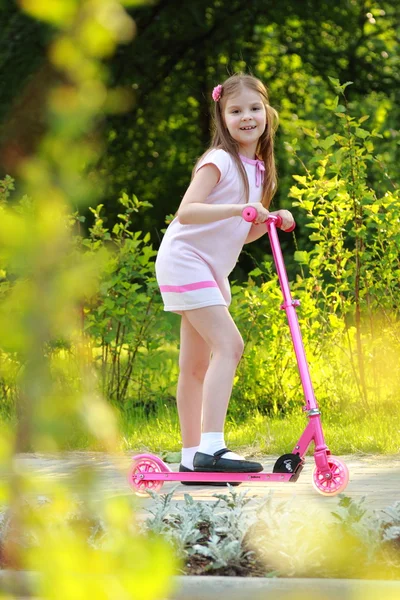 Liten flicka ridning scooter — Stockfoto