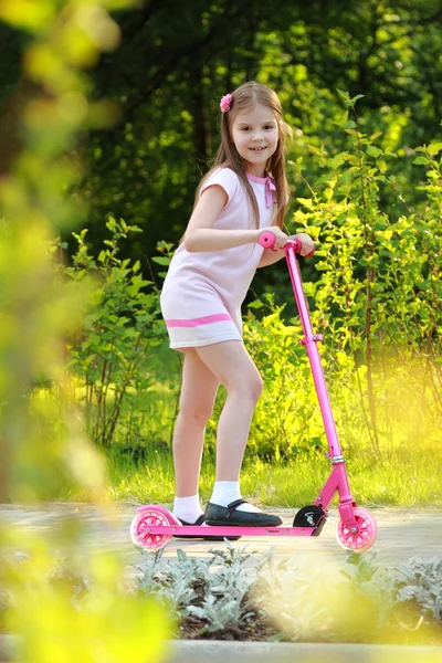 Weinig meisje paardrijden scooter — Stockfoto