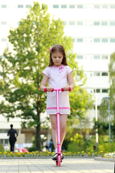 Bambina cavalcando scooter — Foto Stock