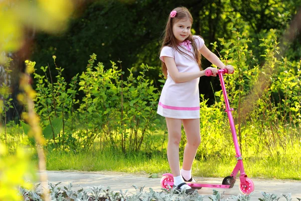 Bambina cavalcando scooter — Foto Stock