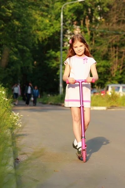 Bambina cavalcando scooter — Foto Stock