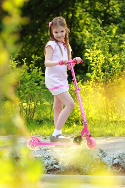 Weinig meisje paardrijden scooter — Stockfoto