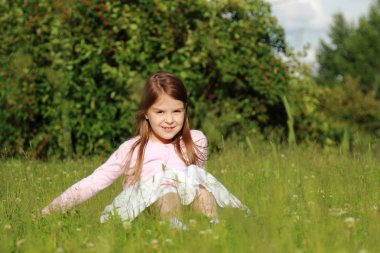 Küçük kız yeşil çimlerde