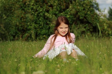 Küçük kız yeşil çimlerde