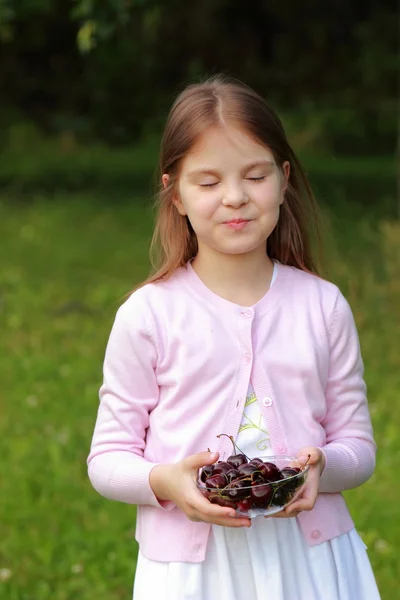Милая маленькая девочка с вишнями — стоковое фото