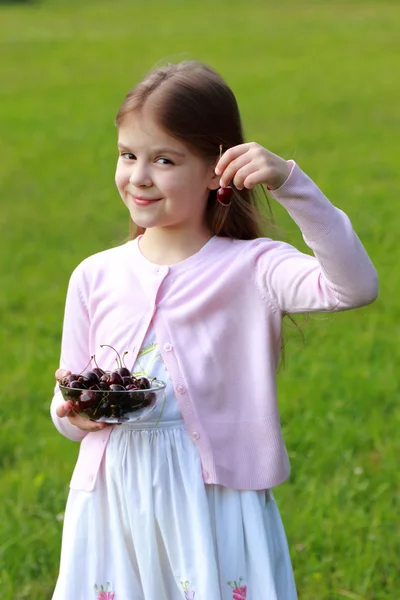 Härlig liten tjej med körsbär — Stockfoto