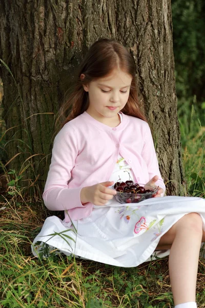 Девочка ест вишни — стоковое фото
