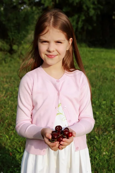 Милая маленькая девочка с вишнями — стоковое фото