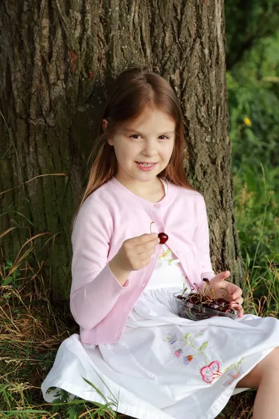 Liten flicka äter körsbär — Stockfoto