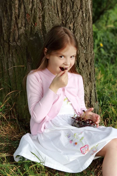 Liten flicka äter körsbär — Stockfoto